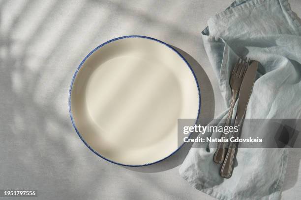 clean empty white plate, fork and knife on pastel grey table. concept for menu with utensil - loja de utensílios de cozinha imagens e fotografias de stock