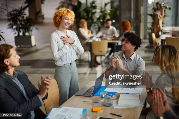 happy entrepreneurs applauding their colleague on a meeting in the office. - bedrijfscultuur stockfoto's en -beelden