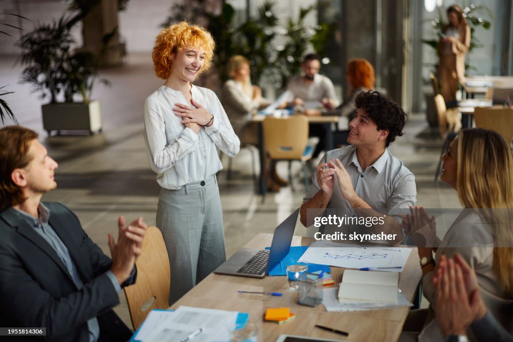 Happy entrepreneurs applauding their colleague on a meeting in the office.