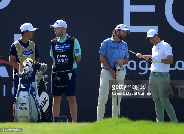 Cameron Young of The United States waits to play his tee shot on the second hole with Rory McIlroy of Northern Ireland and their caddies Paul McBride...