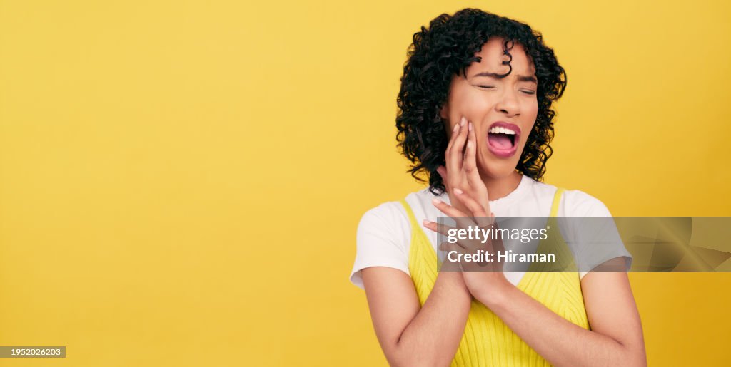 Dental, problem and woman in studio with toothache, pain or cavity on yellow background. Teeth, emergency or female model with broken tooth, inflammation or gum disease, decay or nerve, jaw or injury