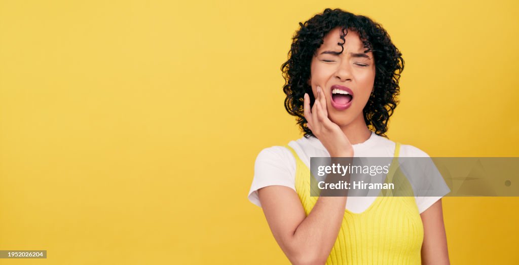 Teeth, problem and woman in studio with toothache, pain or cavity on yellow background. Dental, emergency or female model with broken tooth, inflammation or gum disease, decay or nerve, jaw or injury