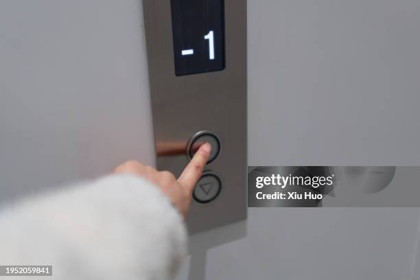 one hand is pressing the elevator button. - ascensor fotografías e imágenes de stock