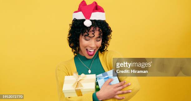 glückliche frau, weihnachten und geschenkbox für die festliche jahreszeit oder dezember, die auf einem gelben studiohintergrund verschenkt wird. aufgeregte junge weibliche person mit geschenk und hut für werbegeschenk oder feier auf mockup-raum - gift lounge stock-fotos und bilder