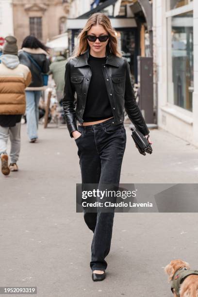 Jessie Andrews wears black top, black leather jacket, black jeans, black flat shoes, outside Sacai, during the Menswear Fall/Winter 2024/2025 as part...