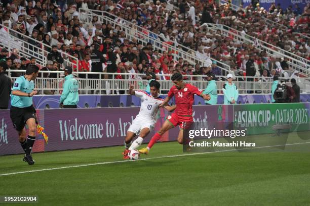 Suphanat Mueanta of Thailand and Ahmed Al Kaabi of Oman compete for the ball during the AFC Asian Cup Group F match between Oman and Thailand at...