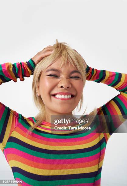 young woman pulling smiling with hands on head - hands on head stock pictures, royalty-free photos & images