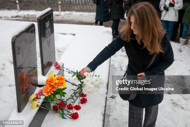Woman lays flowers at memorial plates of Roman Senyk and Oleksandr Badera, the first fallen Heroes of the Heavenly Hundred, during a remembrance...