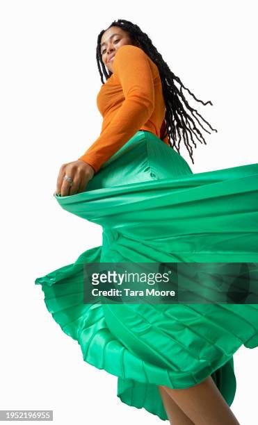 woman holding skirt in motion - green skirt stock pictures, royalty-free photos & images