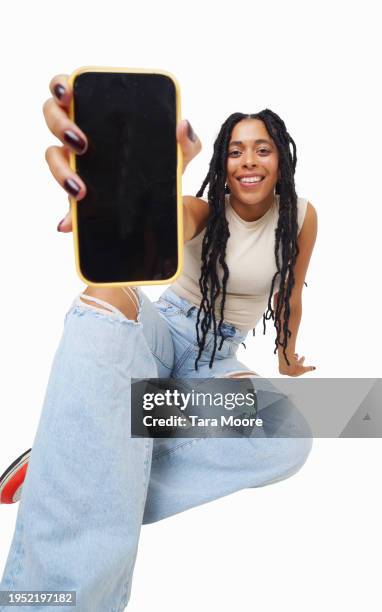 cool woman showing phone to camera - womans hand on hip stock pictures, royalty-free photos & images
