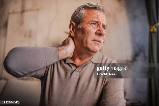 dolor en el cuello, un hombre con una mueca dolorosa en la cara - esguince fotografías e imágenes de stock