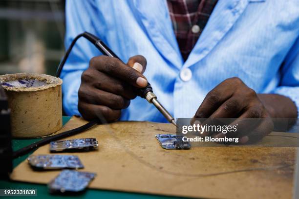 Worker solders components to circuit boards for smartphones at the MiOne factory in the Sino-Uganda Mbale Industrial Park in Mbale, Uganda, on...