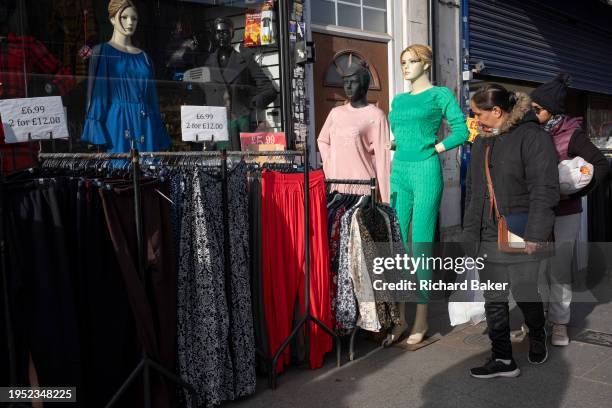 Local women shoppers look at high Street garment styles and fashions which are on display outside a retail business, in Southall West London, on 24th...