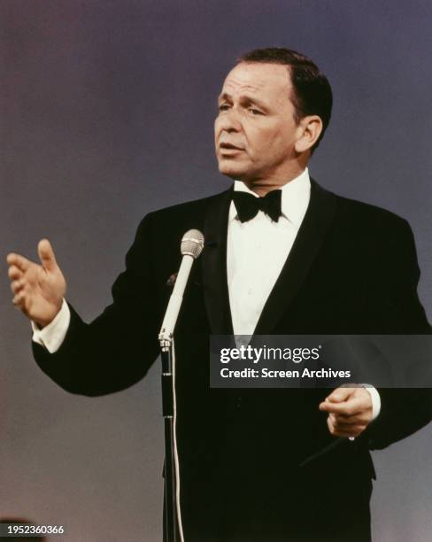 Frank Sinatra performs on stage wearing black tuxedo circa 1965.