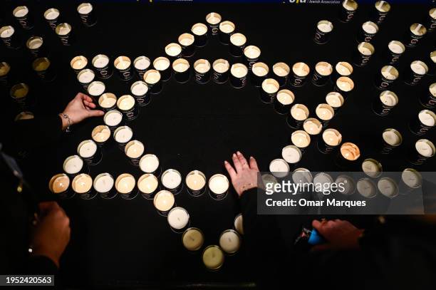 Women light candles in the shape of the Star of David during the symposium on fighting antisemitism on January 22, 2024 in Krakow, Poland. The...