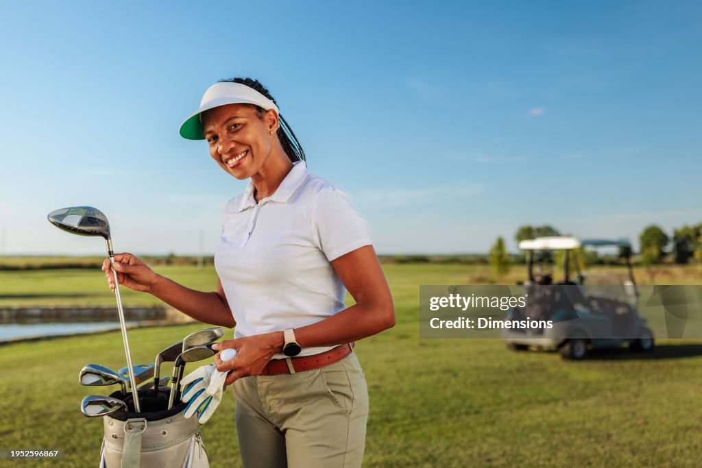 Femme souriante et tenant un club de golf