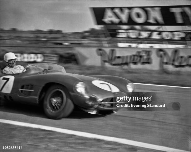 British racing driver Stirling Moss driving an Aston Martin DBR1/300 car to win the RAC Tourist Trophy race at Goodwood Circuit, Sussex, September...