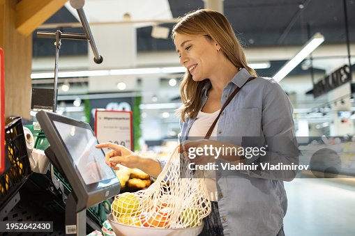 Woman using self service checkout Woman using self service checkout