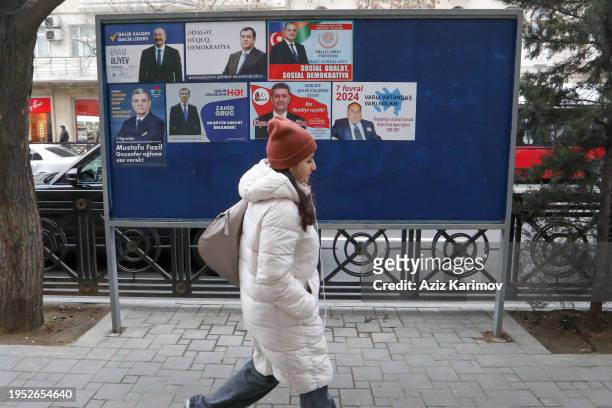 Young girl passes by an electoral billboard in the center of Baku on January 22, 2024 in Baku, Azerbaijan. The president of Azerbaijan, Ilham Aliyev,...