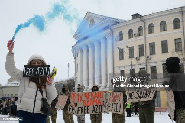 Woman holds colored smoke in her hand and a sign that reads 'Free Azov' during the rally on January 21, 2024 in Kyiv, Ukraine. Participants of the...