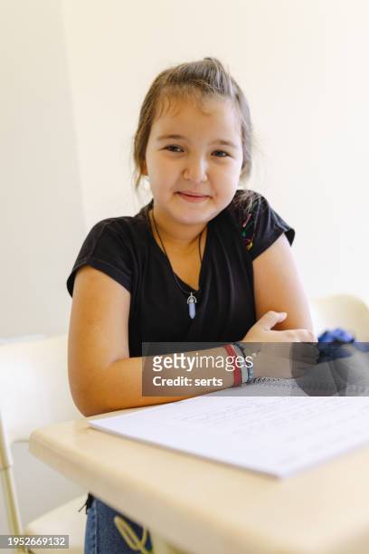 portrait of happy schoolgirl sitting at his school desk in classroom - caucasian 11 12 girl portrait vertical beautiful foto e immagini stock