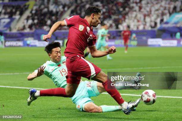 Liu Yang of China tackles Ahmed Al Ganehi of Qatar during the AFC Asian Cup Group A match between Qatar and China at Khalifa International Stadium on...