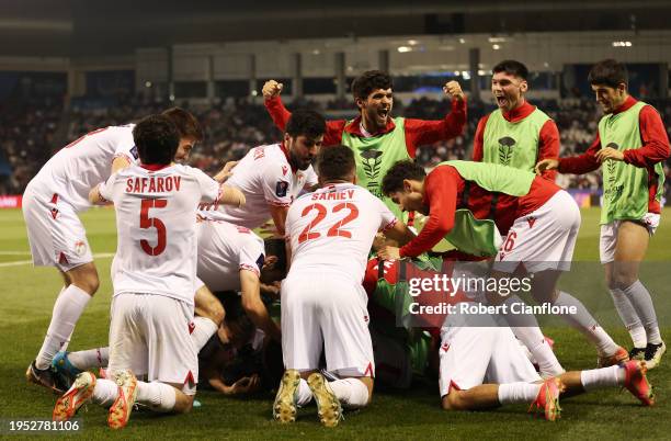 Nuriddin Khamrokulov of Tajikistan celebrates with teammates after scoring his team's second goal during the AFC Asian Cup Group A match between...