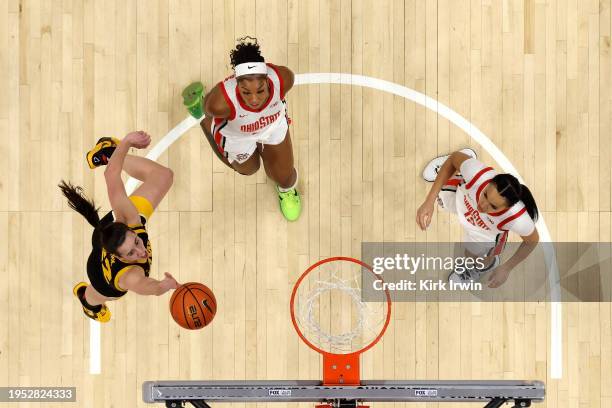 Caitlin Clark of the Iowa Hawkeyes shoots the ball as Cotie McMahon of the Ohio State Buckeyes and Celeste Taylor look for a rebound during the game...