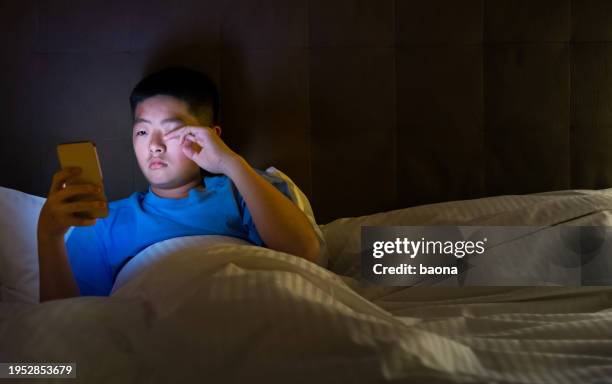 teenage boys using mobile phone in bed - teen sleeping bedroom stock pictures, royalty-free photos & images