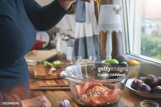 preparing spicy salmon bowl with rice, carrots, cucumber and avocado - marinated stock pictures, royalty-free photos & images