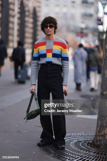 Alex Sánchez de Mora is seen wearing colorful checked jumper, black wide pants, green small Loewe bag, green Loewe sunglasses by Loewe Show during...