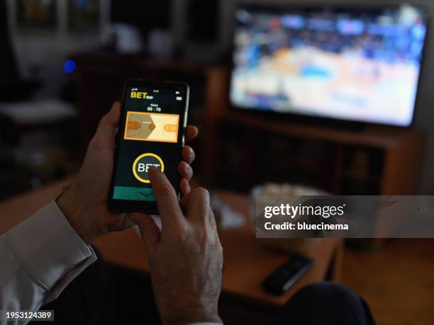hombres maduros que usan teléfonos inteligentes para apuestas deportivas. - apuestas deportivas fotografías e imágenes de stock