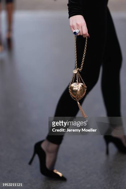 Jurga Fulti seen wearing Vauthier black long catsuit, Etro gold metallic apple shaped mini bag, silver diamond rings and Schiaparelli suede leather...