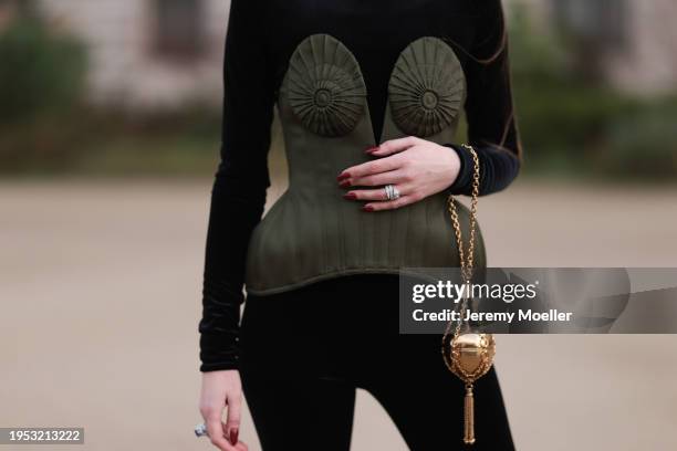 Jurga Fulti seen wearing Schiaparelli khaki green corset top, Alexandre Vauthier black long catsuit, Etro gold metallic apple shaped mini bag, silver...