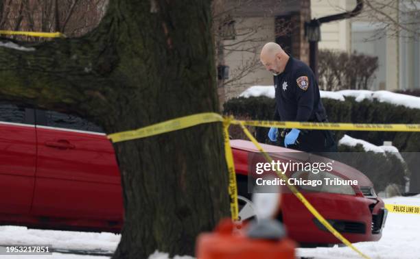 Joliet Police Department Evidence Unit officer walks back to a house where five people were fatally shot by suspect Romeo Nance on Jan. 21, in the...