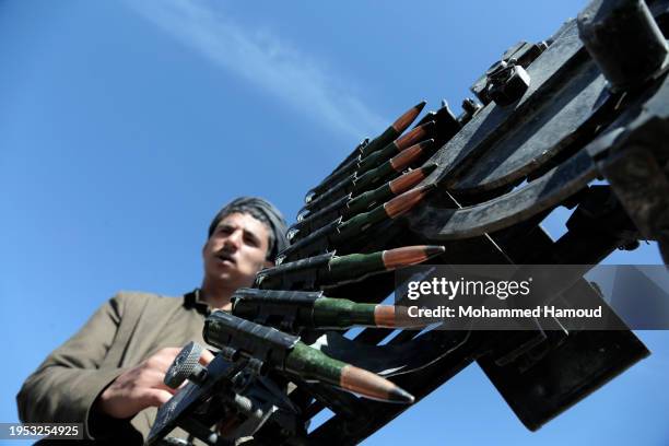 Houthi fighter manning a machine gun mounted on a vehicle during a tribal parade held against the United States-led aerial attacks launched on sites...