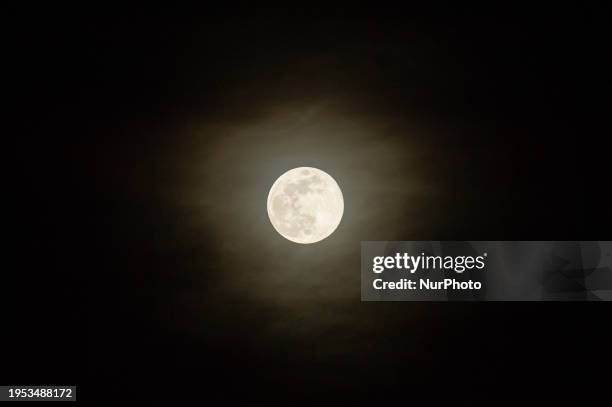 Wolf moon rising behind clouds is seen from Tornimparte , Italy, on January 25th, 2024. Wolf Moon is the initial full moon of the new year and...