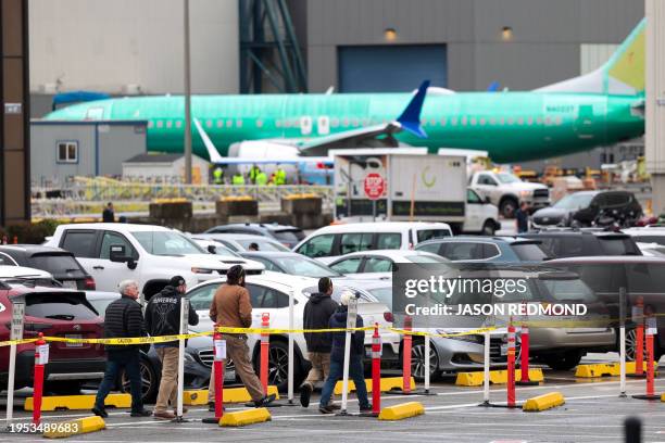Workers and an unpainted Boeing 737 aircraft are pictured as Boeing's 737 factory teams hold the first day of a "Quality Stand Down" for the 737...