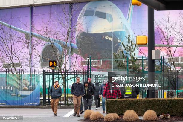 Boeing workers are pictured exiting a gate below an image of a Boeing 737-800 aircraft as Boeing's 737 factory teams hold the first day of a "Quality...
