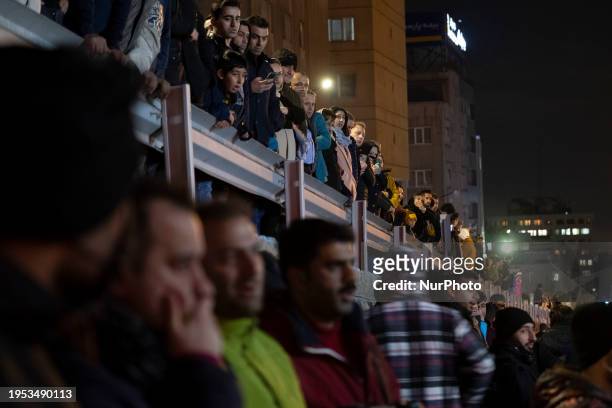 People are watching while standing at the site of the fire at the Gandhi hotel hospital in northern Tehran, Iran, on January 25, 2024. Patients are...
