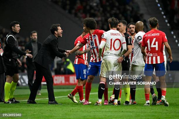 Atletico Madrid's Argentinian coach Diego Simeone holds Atletico Madrid's Belgian midfielder Axel Witsel as others players speak with Spanish referee...