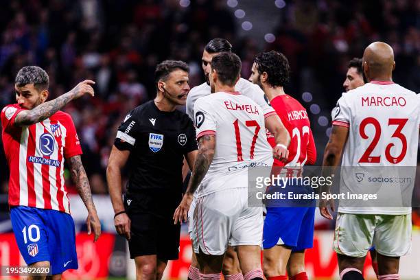 Referee Jesús Gil Manzano talks to Erik Lamela of Sevilla during the Quarter Finals of Copa del Rey match between Atletico Madrid and Sevilla FC at...