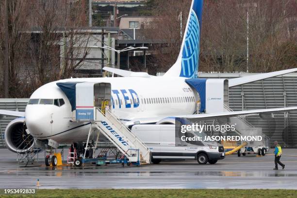 Person walks past a Boeing 737 MAX 8 for United Airlines parked at Renton Municipal Airport adjacent to Boeing's factory in Renton, Washington, on...