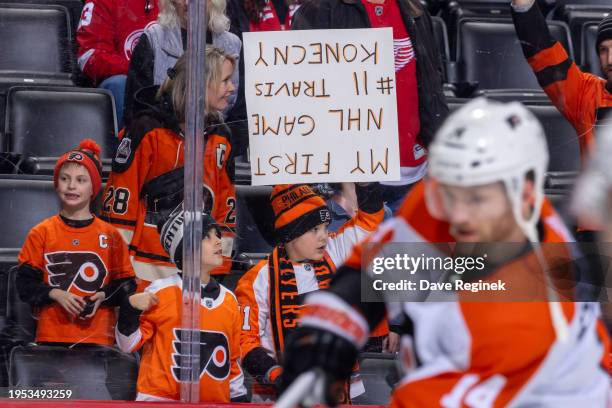 Young Philadelphia Flyers fan holds hi up side down sign during warm ups before the game against the Detroit Red Wings at Little Caesars Arena on...