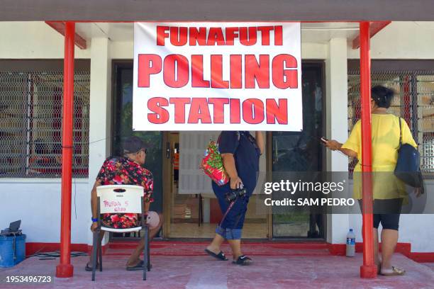 This photo taken on January 25, 2024 shows People standing and sitting outside a polling station on election day in Funafuti, the capital of the...