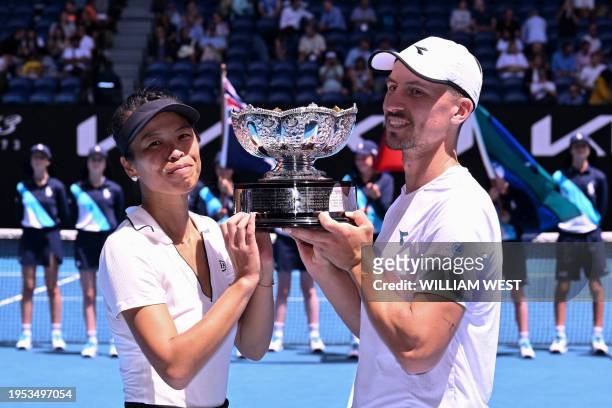 Taiwan's Su-wei Hsieh and her partner Jan Zielinski of Poland celebrate with the trophy following their victory against Britain's Neal Skupski and...