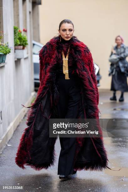Guest wears oversized red faux fur coat outside Georges Hobeika during the Haute Couture Spring/Summer 2024 as part of Paris Fashion Week on January...