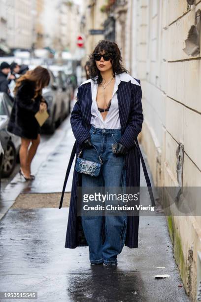 Xiayan Guo wears denim jeans, Valentino bag, striped navy coat, white blouse, black laced bra outside Georges Hobeika during the Haute Couture...