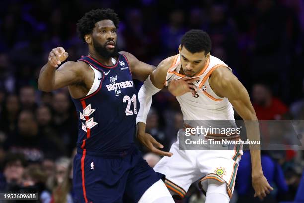 Joel Embiid of the Philadelphia 76ers and Victor Wembanyama of the San Antonio Spurs jostle during the first quarter at the Wells Fargo Center on...