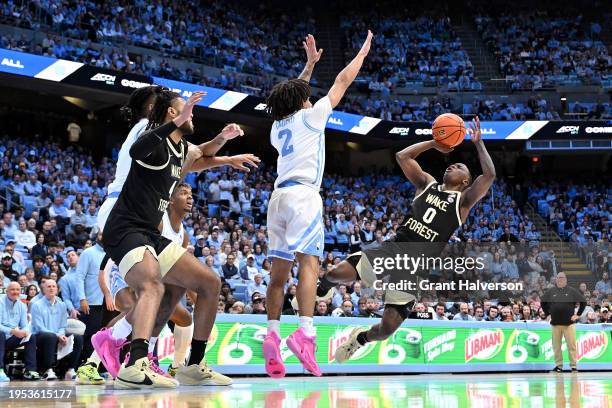 Kevin Miller of the Wake Forest Demon Deacons takes an off-balance shot against Elliot Cadeau of the North Carolina Tar Heels during the first half...